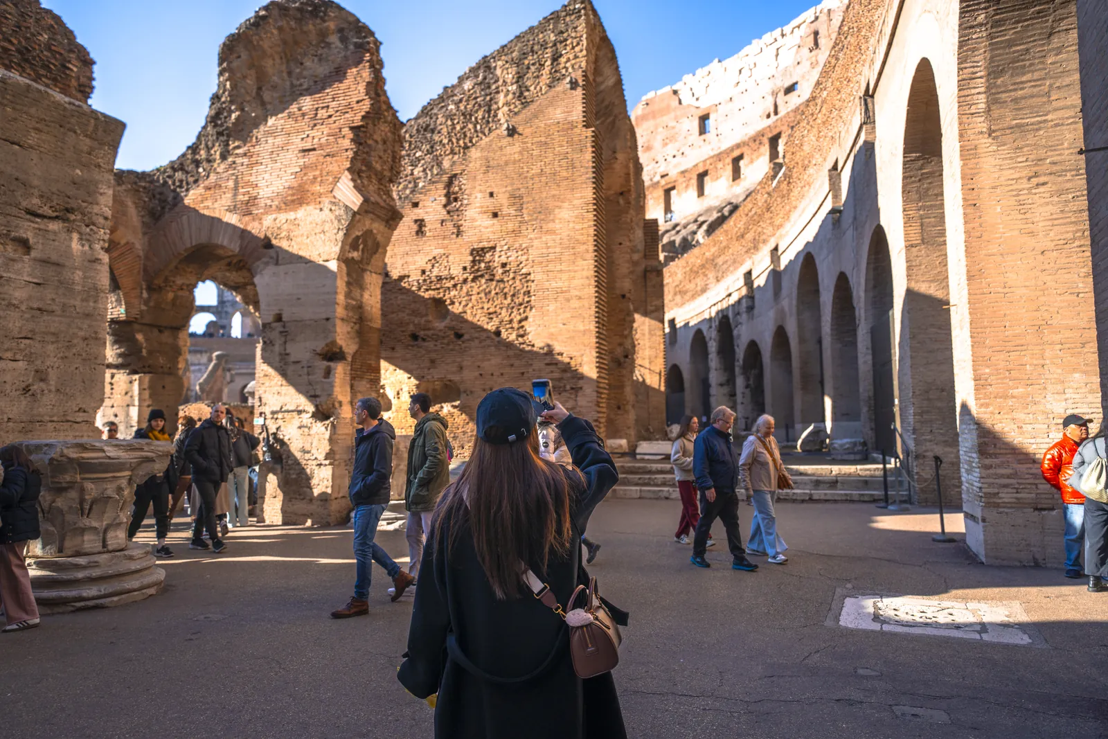 A small group walking through the ground floor of the Colosseum